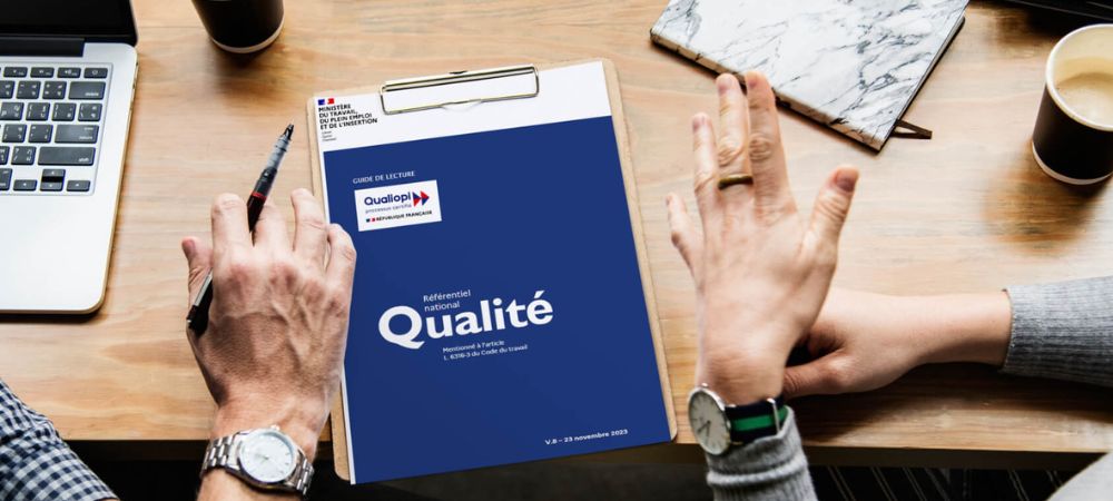 Mains de personnes utilisant le guide Qualiopi