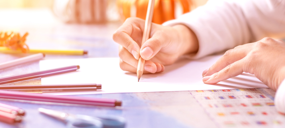 Main écrivant avec un crayon