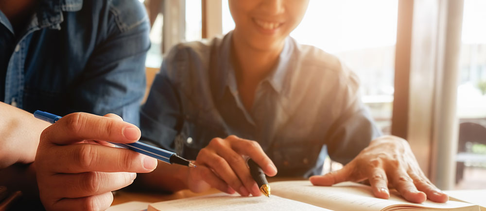 Deux personnes écrivant sur des documents