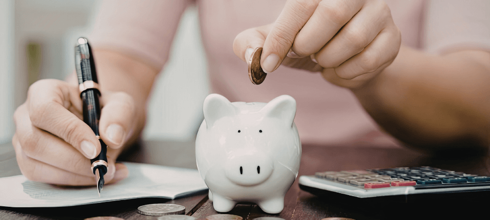 Femme qui met de l'argent dans une tirelire