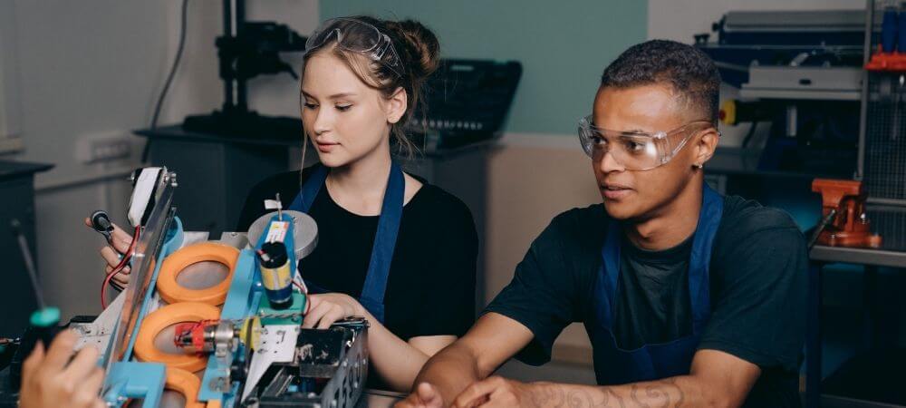 Deux apprentis travaillant sur une machine